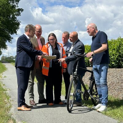 Kommunale Vertreter besprechen die Sanierung des Radweges vor Ort