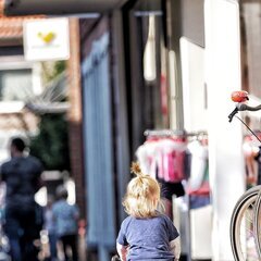 Kind auf Laufrad in der Fußgängerzone